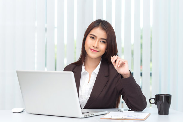 迷人的年轻女商人和笔记本电脑在办公室处理文件图片下载