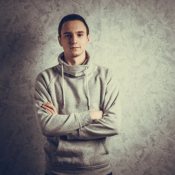 一个英俊的年轻人的肖像在蓝色的背景下微笑图片下载