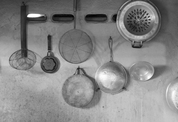 厨具挂在水泥墙上，色调单一。图片下载