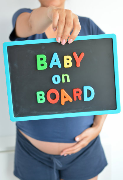 孕妇抱着婴儿在船上的腹部上彩色文字图片下载