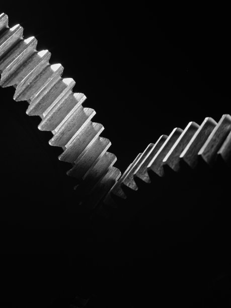 黑色背景上的两个金属齿轮。图片下载