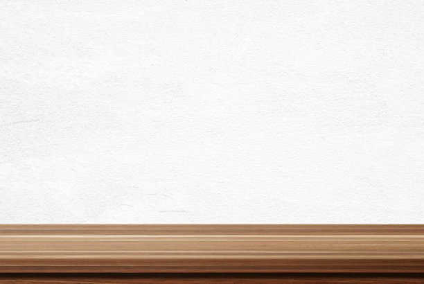 白色水泥墙背景上的空木桌图片下载