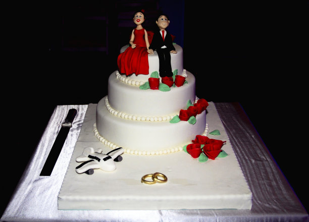 订婚夫妇在婚礼蛋糕上图片下载