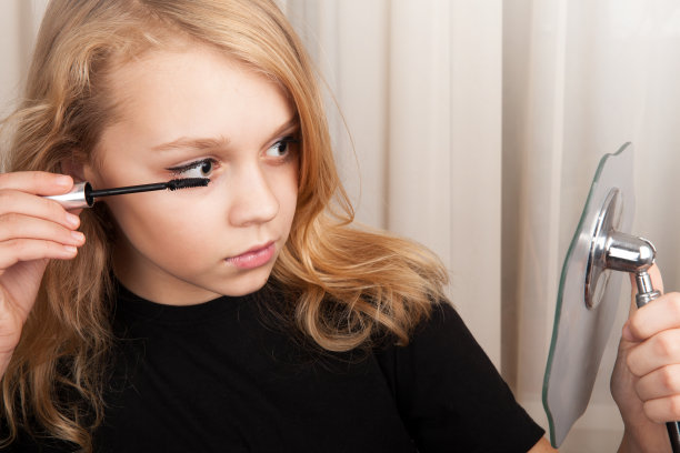 金发美丽的白人女孩画睫毛图片下载