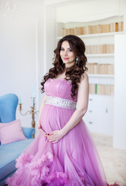 怀孕，母性和期望的概念-一个孕妇穿着粉红色的晚礼服微笑图片下载