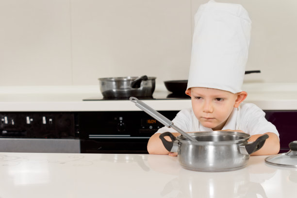 正在做饭的小男孩弯下腰去闻食物图片下载