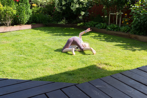 女孩在美丽的花园里的草坪上玩耍图片下载