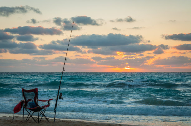 日落时分海滩上渔夫的空椅子图片下载