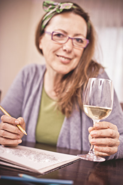 成熟的女人配上一杯白葡萄酒图片下载