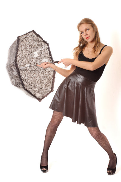 黑伞下的女人，背靠白墙图片下载