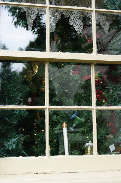 透过玻璃窗的烛光和圣诞树图片下载
