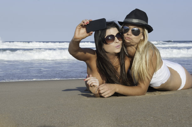 两个年轻漂亮的女人正在用手机自拍图片下载