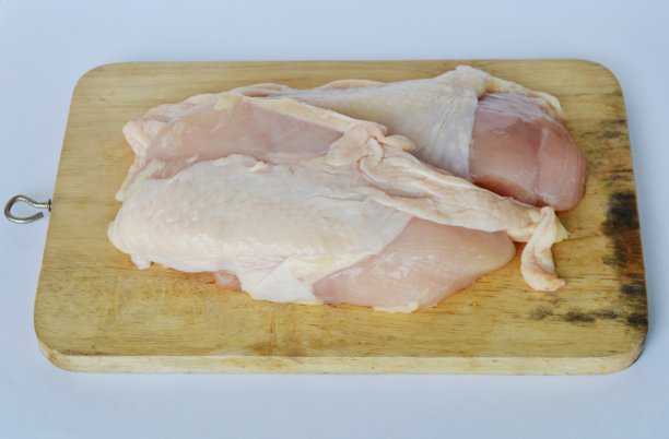 生鸡肉放在木砧板上图片下载