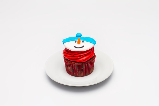 圣诞纸杯蛋糕，托盘上有奶油糖霜。雪人图片下载