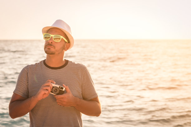 游客肖像与复古相机在海滩图片下载