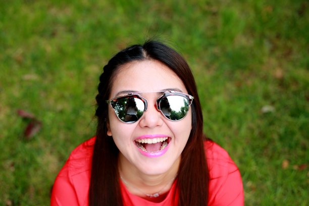 年轻女子戴着太阳镜看相机图片下载