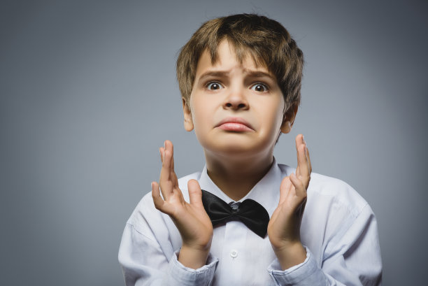 特写的英俊男孩与惊讶的表情，而站图片下载