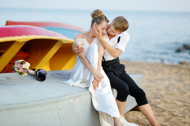 新娘和新郎在海滩上拥抱图片下载