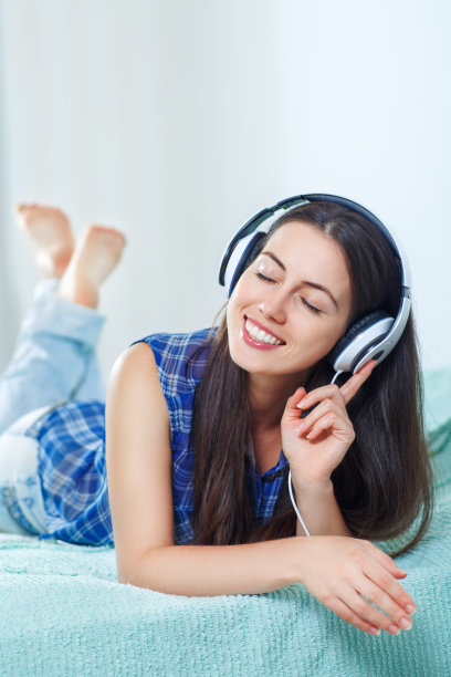 女孩在家里戴着耳机听音乐图片下载