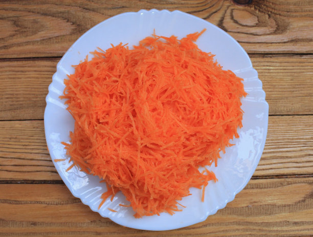 把胡萝卜磨碎放在白盘子里做沙拉图片下载