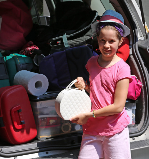 戴帽子的漂亮小女孩把东西装进箱子里图片下载