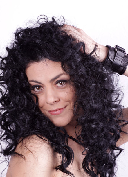 漂亮的黑发女人，长而卷的头发图片下载