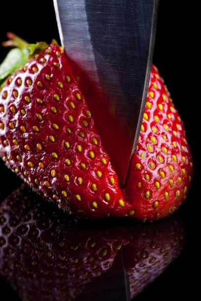 库克在一张玻璃桌子上切草莓。图片下载