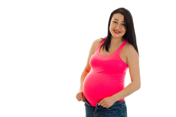 有趣的怀孕女孩，黑色的头发触摸她的大肚子，看着相机孤立在白色的背景图片下载