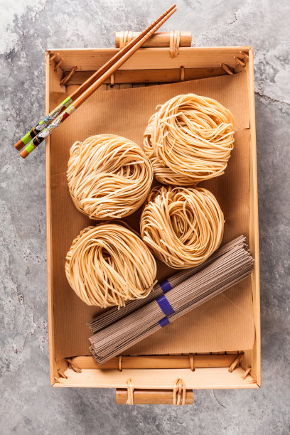 一捆荞麦，一捆荞麦荞麦面和新鲜的自制亚洲拉面。酱油和筷子。生的食物原料面条和新鲜的亚洲面条。酱油和筷子。生的食品图片下载