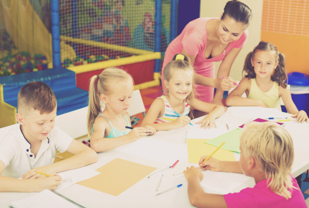 孩子们在老师的帮助下在教室里学习图片下载