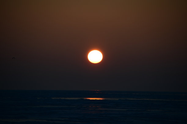 冻结的海面上的日落。图片下载