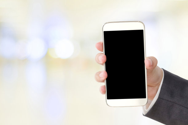 商人手持智能手机在模糊的背景图片下载