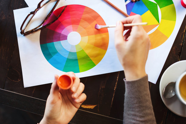 女人的手拿着桌上的颜料、铅笔和图画图片下载