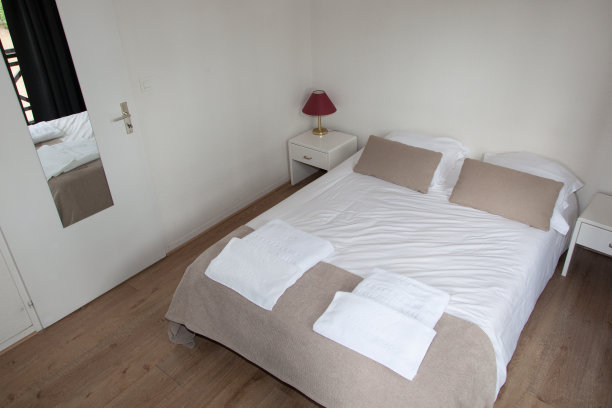 卧室里的双人床，旁边有台灯图片下载