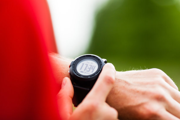 一名男子正在查看显示军事时间的手表图片下载