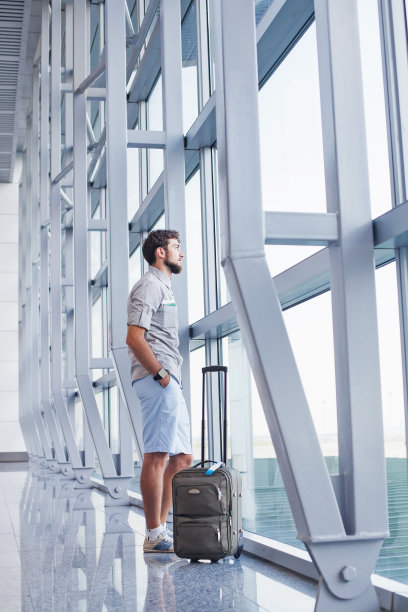 一个在国际机场等飞机的男人图片下载