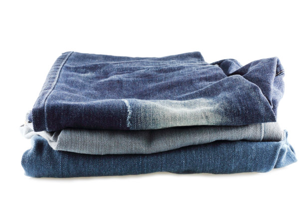 许多牛仔裤孤立地堆放在白色的背景上图片下载