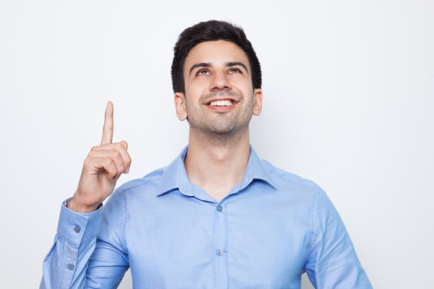 快乐的年轻有吸引力的男人指着上面图片下载