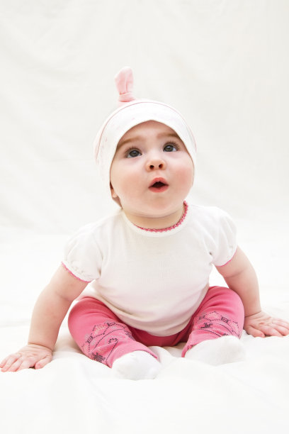 可爱的小女孩坐在地板上，在摄影棚拍摄图片下载