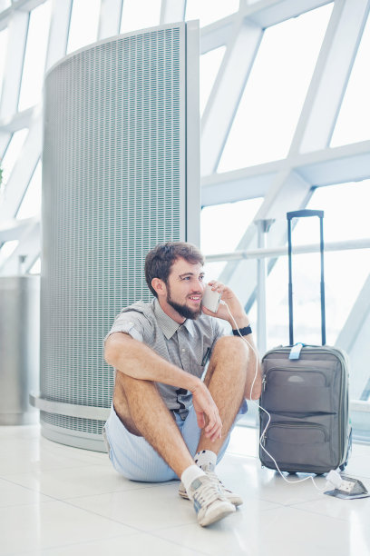 一个正在等飞机打电话的男人图片下载