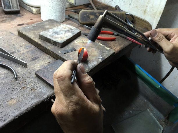 一个金工正在对金戒指点火图片下载