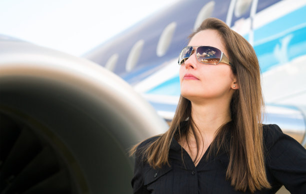 站在一架喷气式飞机旁的女商人图片下载
