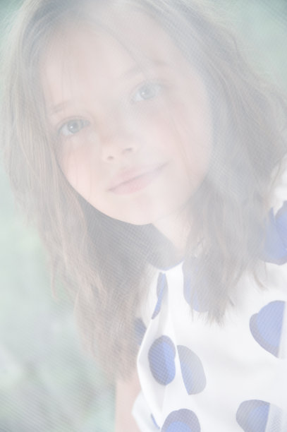 一个8岁女孩的肖像后面的网眼薄纱。图片下载