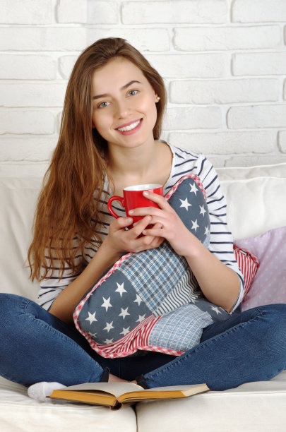 放松的女人舒服地坐在沙发上图片下载