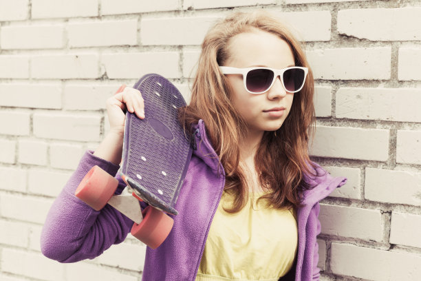 金发少女戴着太阳镜拿着滑板图片下载