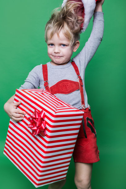 穿着红色侏儒服装的孩子拿着圣诞礼物图片下载