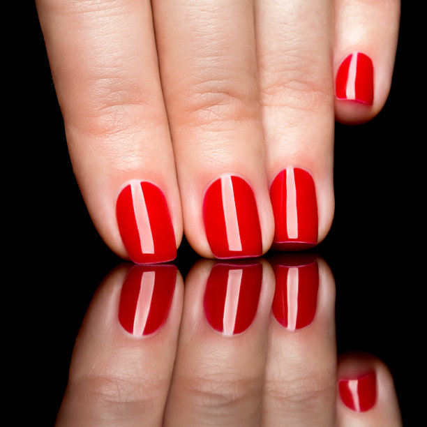 女人涂着红色指甲油的手图片下载