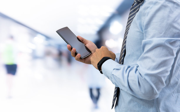 有智能腕带和智能手机的商人素材图片