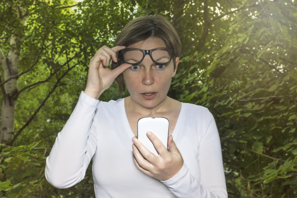 惊讶的女人看着手机图片下载