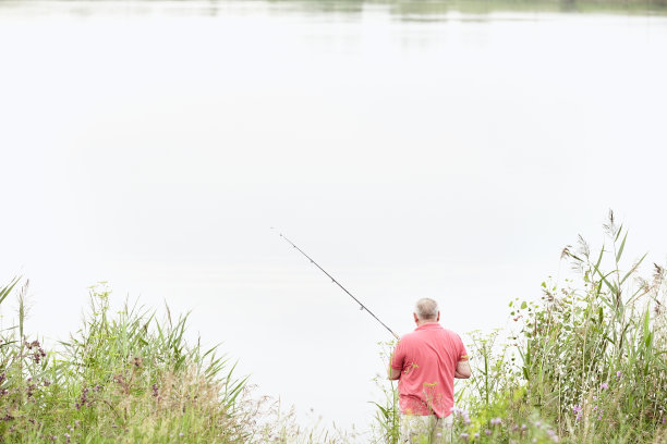 成熟的垂钓者在湖上捕鱼图片下载